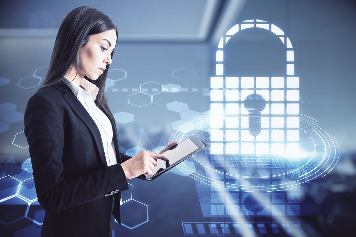 Business professional using a tablet with a glowing digital interface, symbolising Auro Technologies' innovative approach to security technology