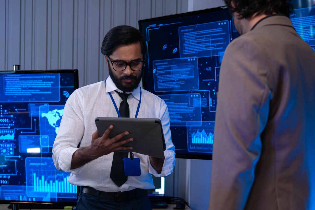 Focused technology professionals working in a data control centre, providing 24-hour security system support